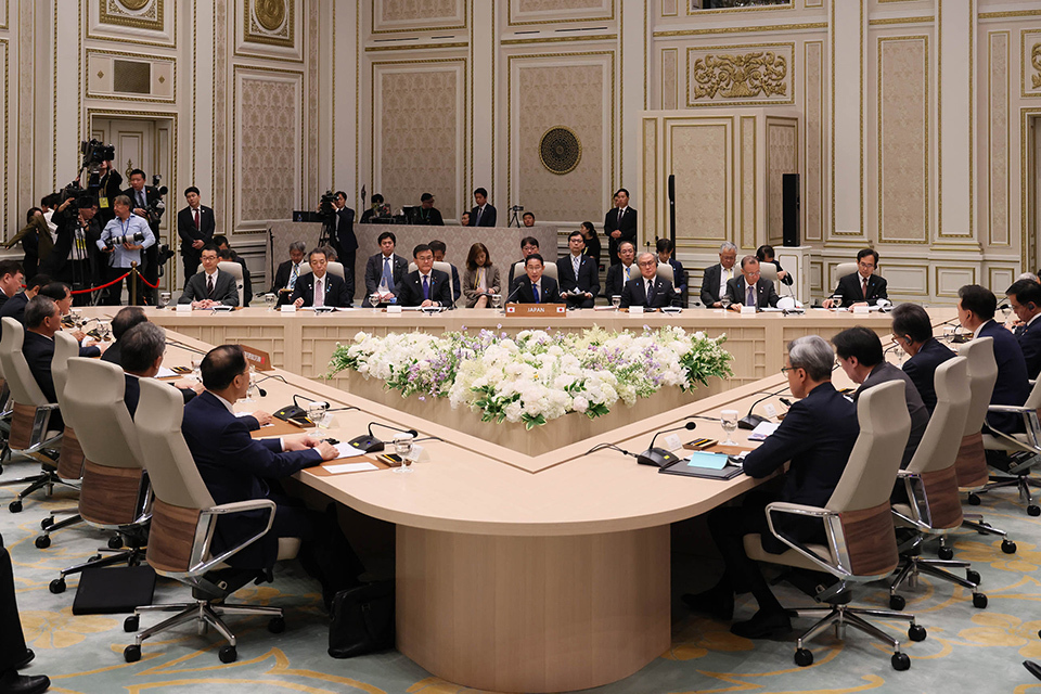 A triangular table surrounded by a group of people